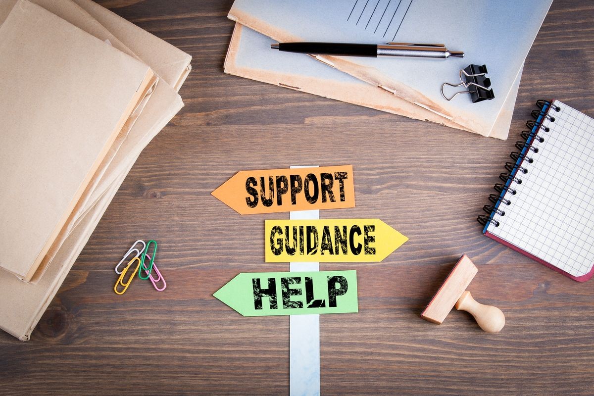 Support, Guidance and Help concept. Paper signpost on a wooden desk. Customer service and marketing Support, Guidance and Help concept. Paper signpost on a wooden desk. Customer service and marketing